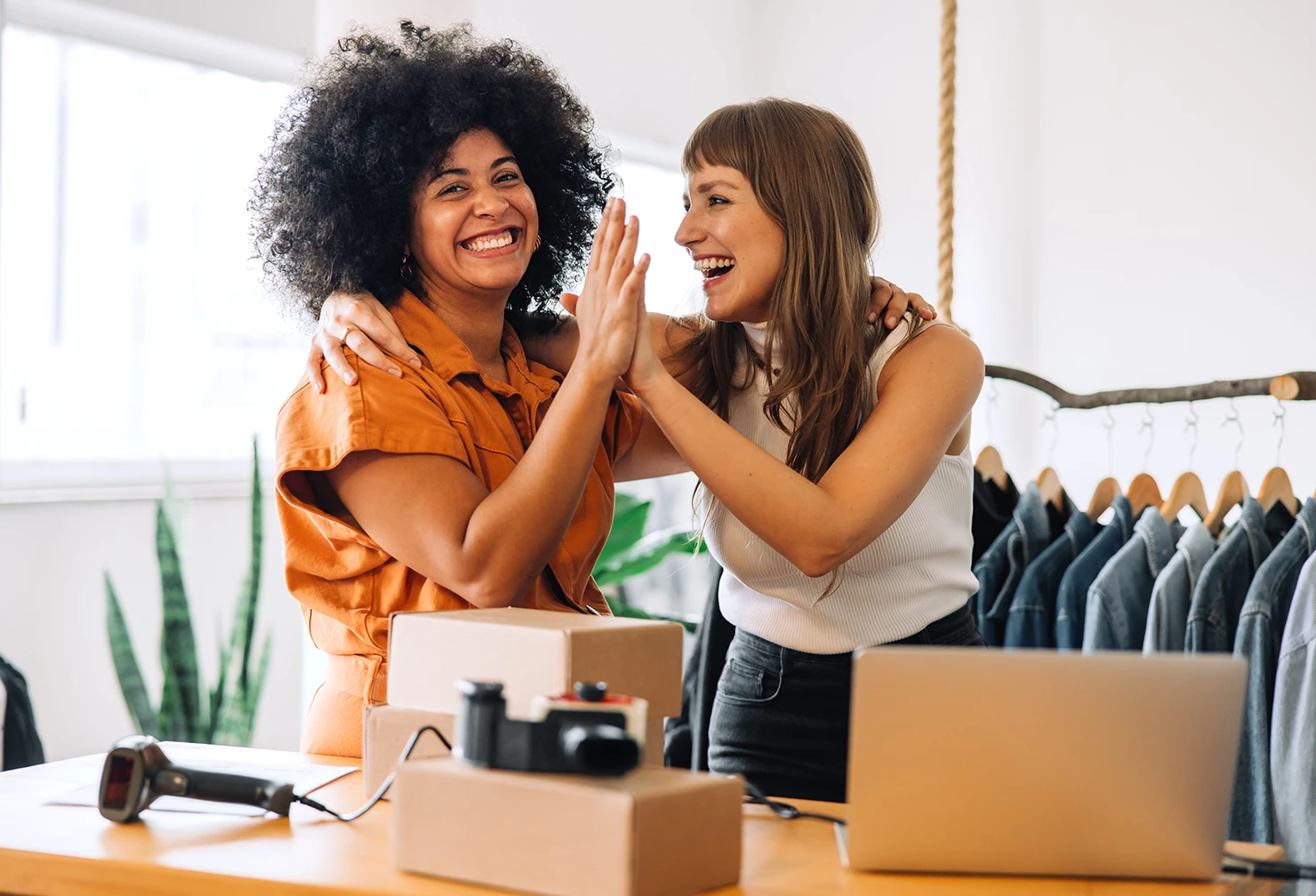 A pair of female small business owners high-fiving